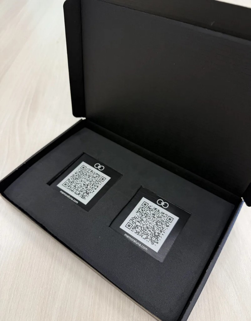 Les deux plaques QR code Memoraluna gravées, dans leur étui de livraison.